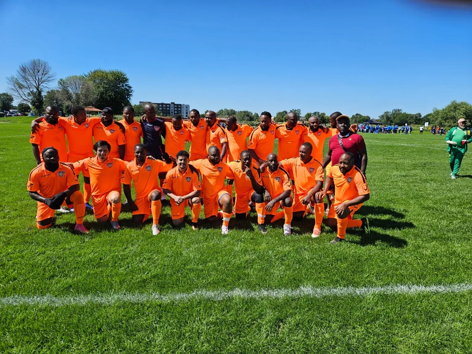 CAVFC team photo in orange kits at a veterans tournament
