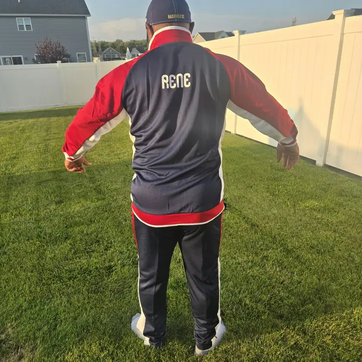 A member showing the back of a navy and red club tracksuit