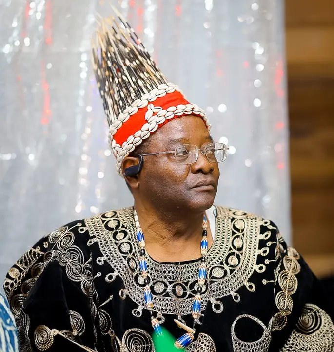 Elder in a porcupine-quill crown and embroidered black robe