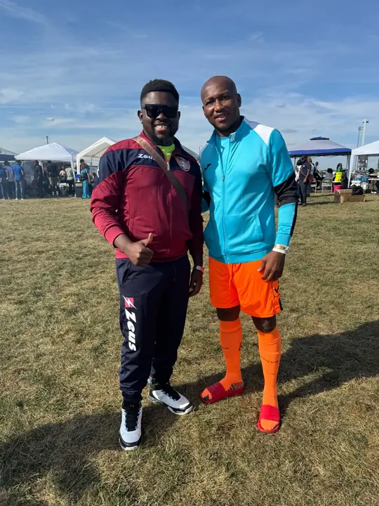 Two members at a tournament, one in a maroon jacket and one in a turquoise kit
